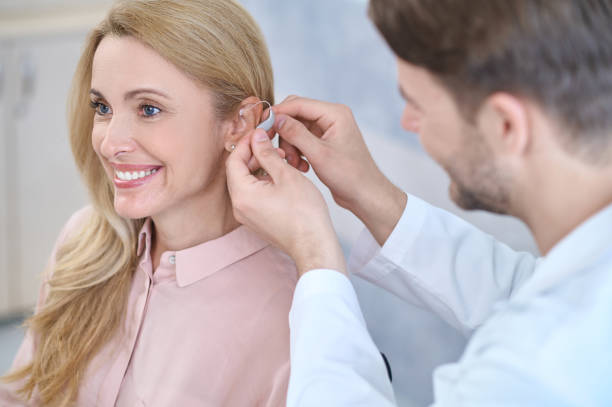 Professional audiologist conducting comprehensive hearing examination with patient